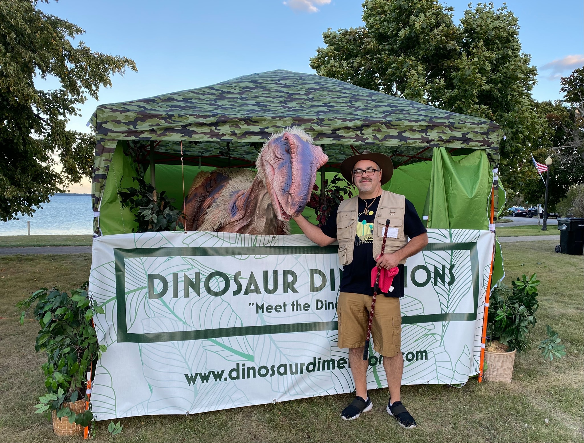 man standing next to dinosaur